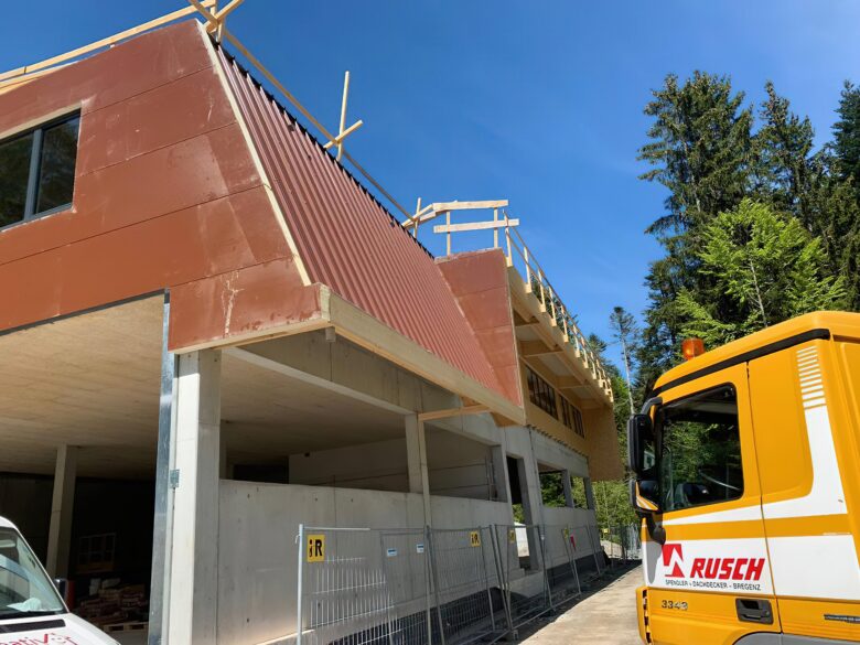 Ein Fassadenbau- und Spenglerei Job während der Bauphase, neben einem RUSCH LAUTERACH LKW.