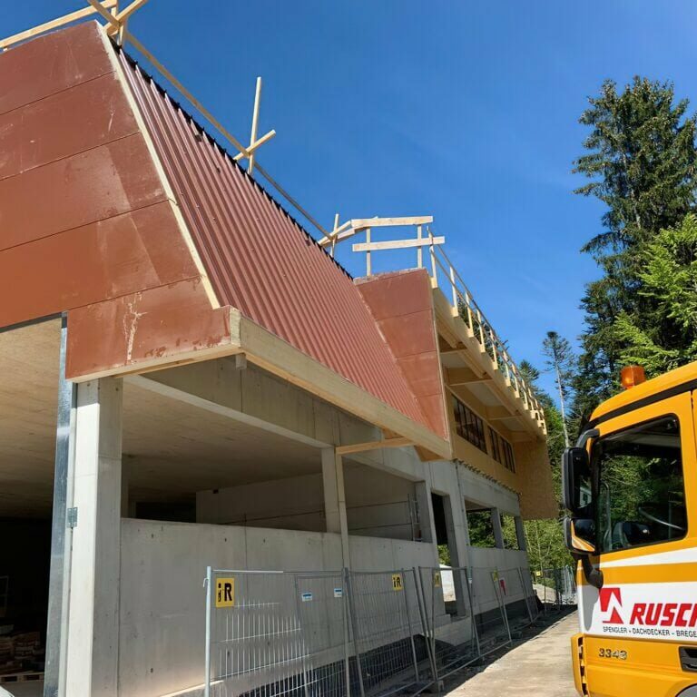 Ein Fassadenbau- und Spenglerei Job während der Bauphase, neben einem RUSCH LAUTERACH LKW.